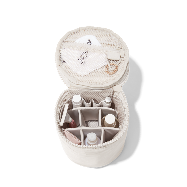 hover - Dagne Dover large Mila Toiletry Pouch in white unzipped filled with toiletry products.