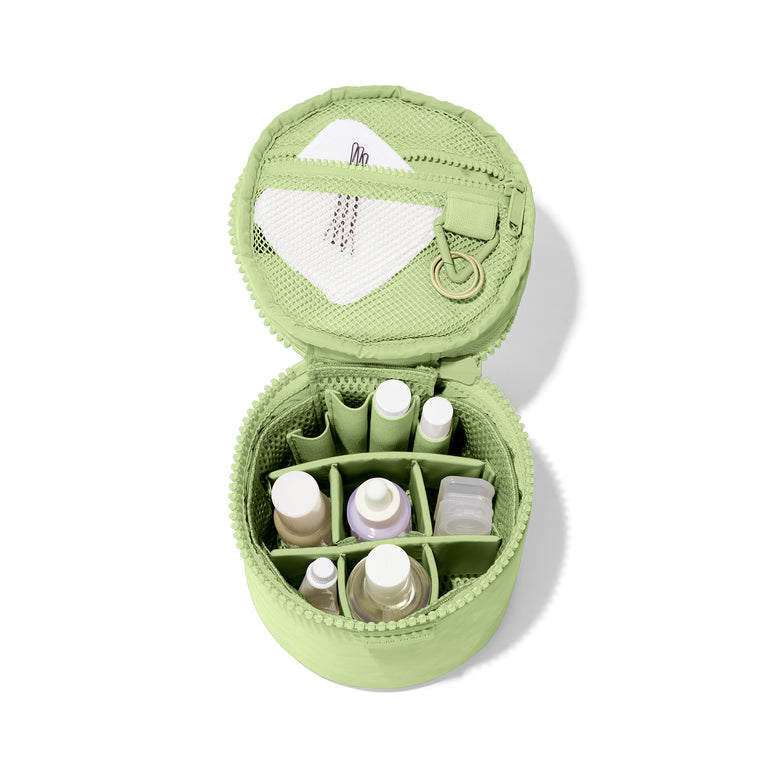 hover Dagne Dover small Mila Toiletry Pouch in matcha green unzipped filled with toiletry products.