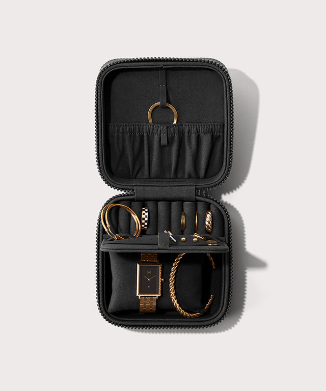 Dagne Dover Large Frankie Jewelry Case in black, seen open from above with jewelry inside the interior compartment.