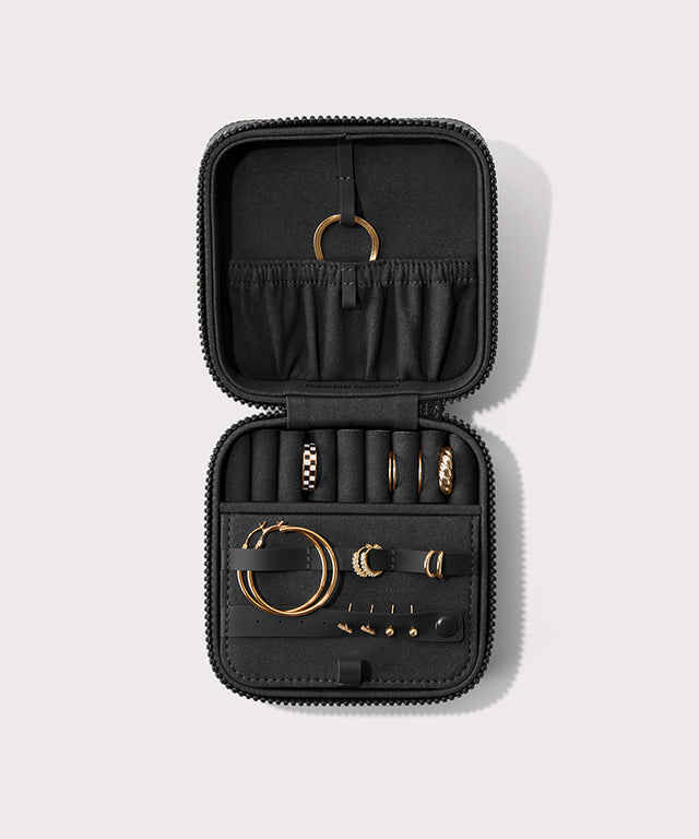 Dagne Dover Large Frankie Jewelry Case in black, seen open from above with jewelry inside the interior compartment.