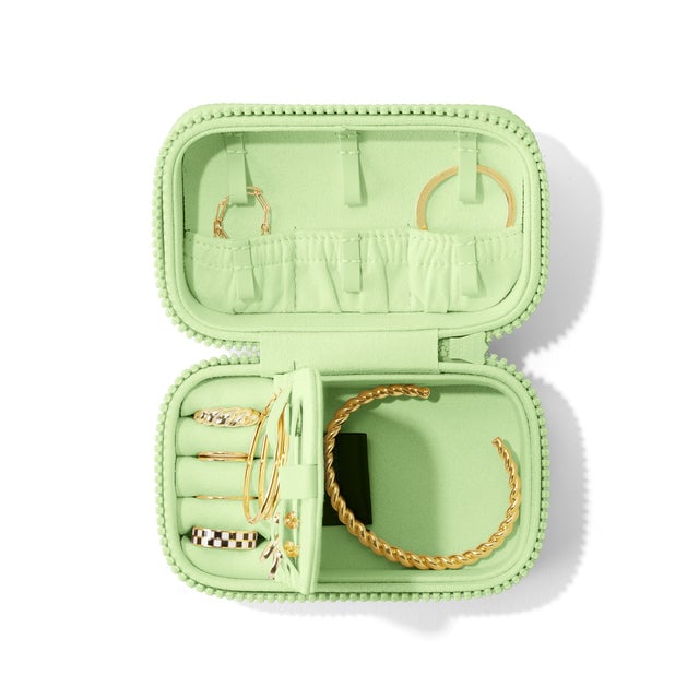 Dagne Dover Small Frankie Jewelry Case in a matcha green, seen open from above with jewelry inside the interior compartment.
