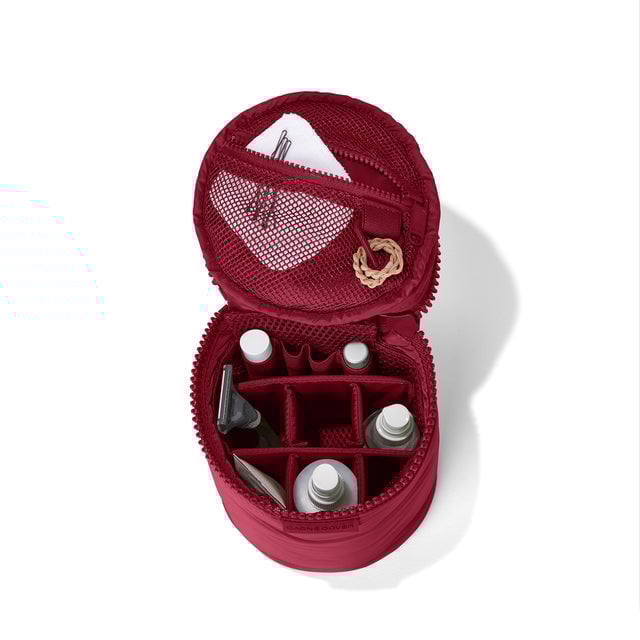 hover Dagne Dover large Mila Toiletry Pouch in spice red unzipped filled with toiletry products.