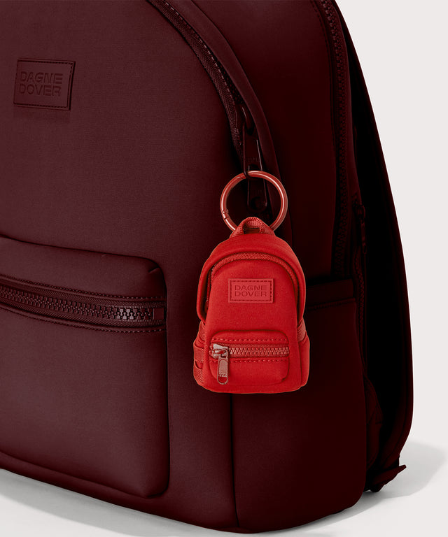 Dagne Dover Dakota Keychain in a fiery, saturated red leaning toward orange clipped onto a backpack.