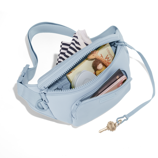 Dagne Dover jax large Fanny Pack in an airy, lighter sky blue unzipped, exposing the interior pockets. hover
