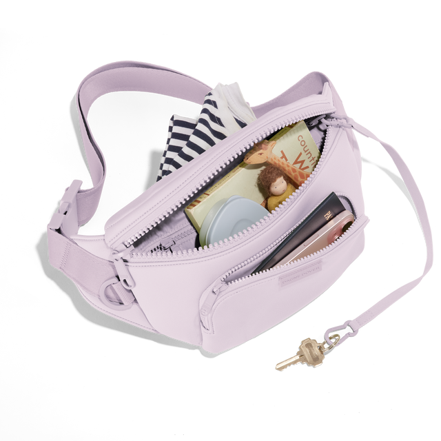 Dagne Dover jax large Fanny Pack in a soft purple with grey undertones unzipped, exposing the interior pockets. hover