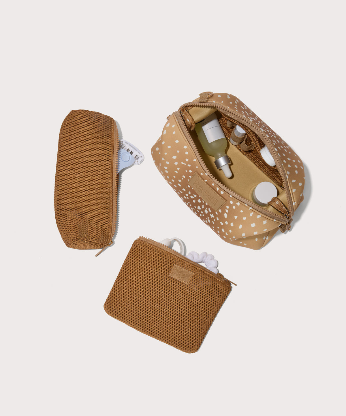 Hunter Large toiletry bag in an understated, neutral fawn print with a range of rich browns unzipped, top down view. 
