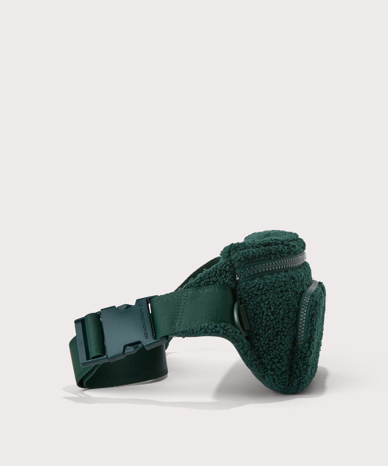 Jax fanny pack in a saturated, jewel-toned deep green with bold blue undertones..  side angle view  In a  Faux Shearling  a soft, wool-like plush made with recycled materials

