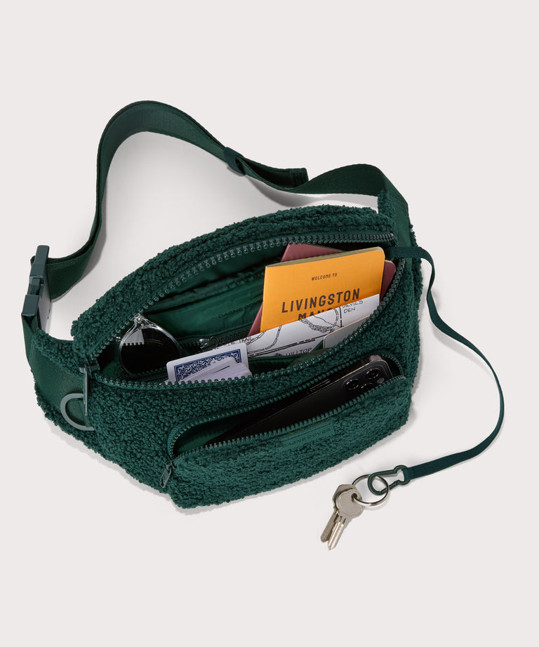 Jax fanny pack in a saturated, jewel-toned deep green with bold blue undertones . unzipped, top down view.  In a  Faux Shearling  a soft, wool-like plush made with recycled materials
