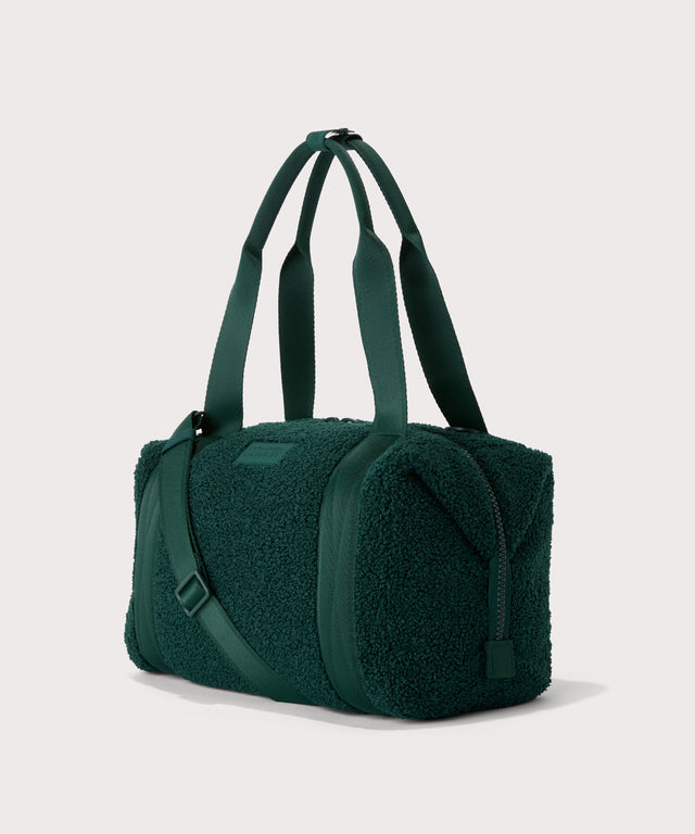 Medium landon carryall in a saturated, jewel-toned deep green with bold blue undertones..  side angle view  In a  Faux Shearling  a soft, wool-like plush made with recycled materials
