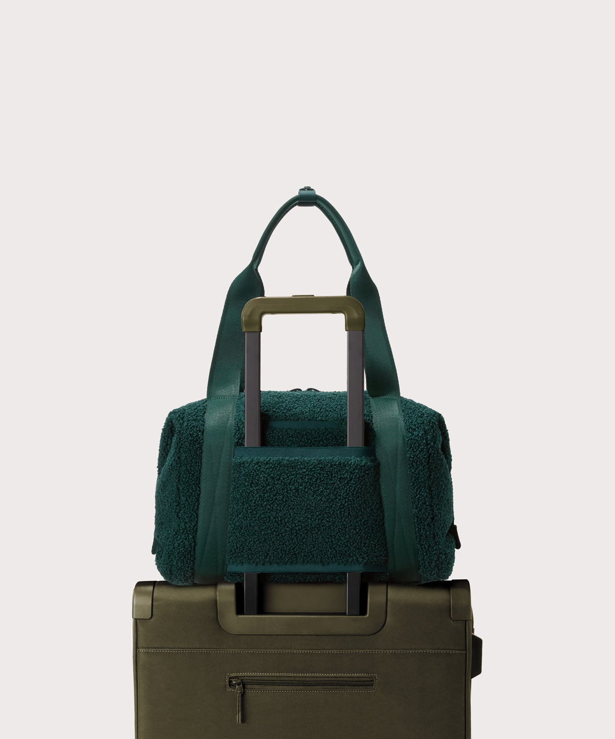 Medium landon carryall in a saturated, jewel-toned deep green with bold blue undertones..  displaying luggage sleeve
