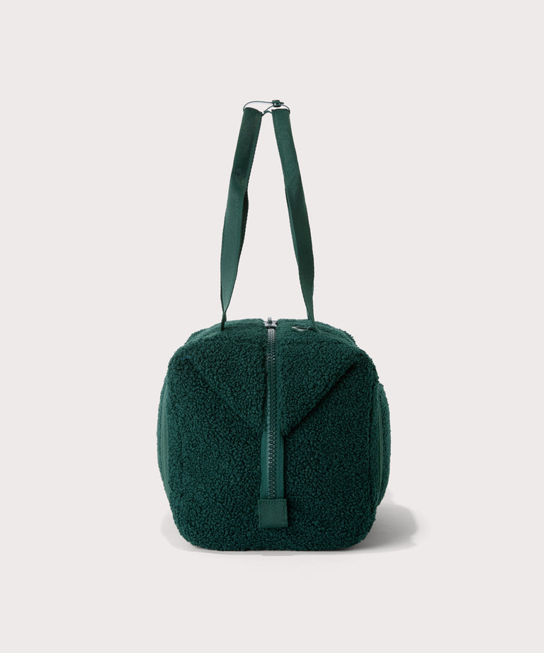 Medium landon carryall in a saturated, jewel-toned deep green with bold blue undertones., side view  In a  Faux Shearling  a soft, wool-like plush made with recycled materials

