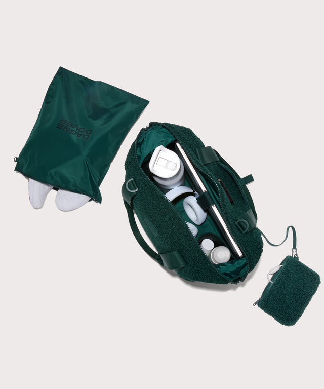 Medium landon carryall in a saturated, jewel-toned deep green with bold blue undertones. . unzipped, top down view.  In a  Faux Shearling  a soft, wool-like plush made with recycled materials
