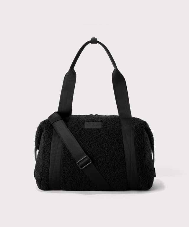 Medium landon carryall in a black. In a  Faux Shearling  a soft, wool-like plush made with recycled materials. front angle. 