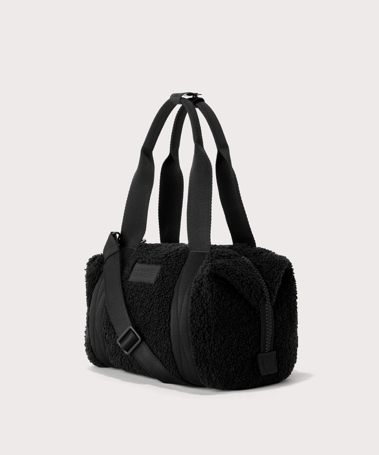 small landon carryall in a black..  side angle view  In a  Faux Shearling  a soft, wool-like plush made with recycled materials
