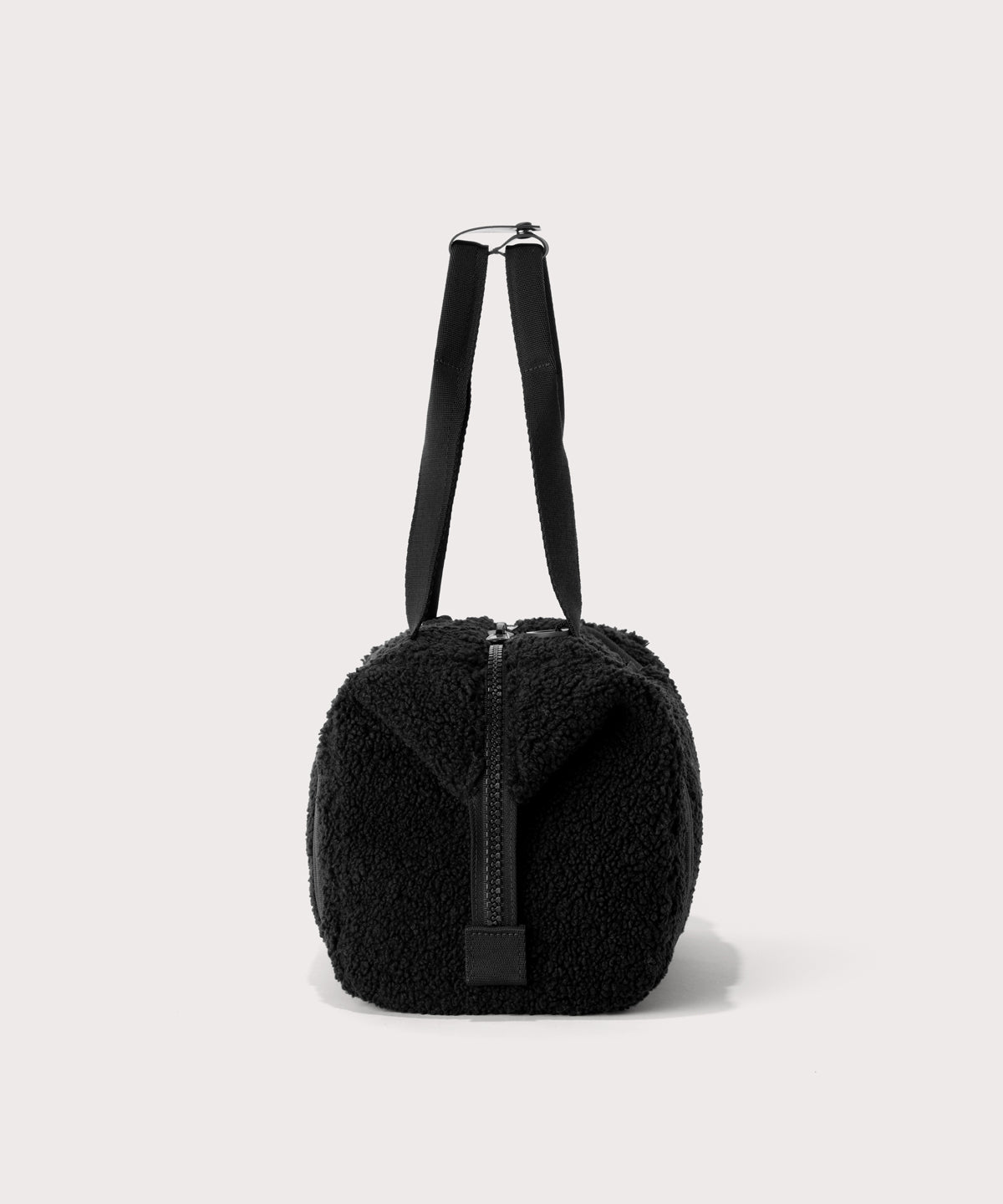 small landon carryall in a black., side view  In a  Faux Shearling  a soft, wool-like plush made with recycled materials
