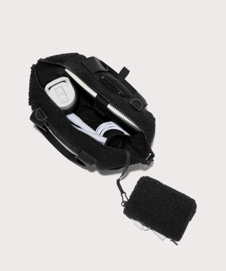 small landon carryall in a black . unzipped, top down view.  In a  Faux Shearling  a soft, wool-like plush made with recycled materials
