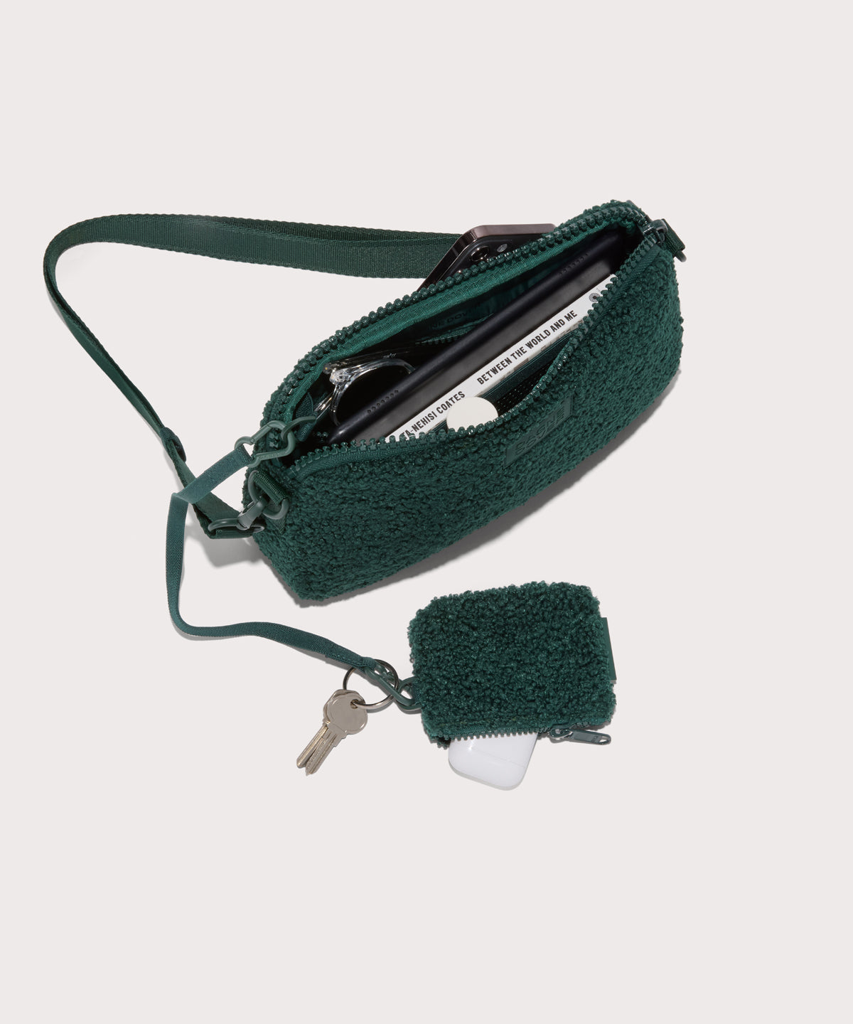 nora shoulder bag in a saturated, jewel-toned deep green with bold blue undertones . unzipped, top down view.  In a  Faux Shearling  a soft, wool-like plush made with recycled materials

