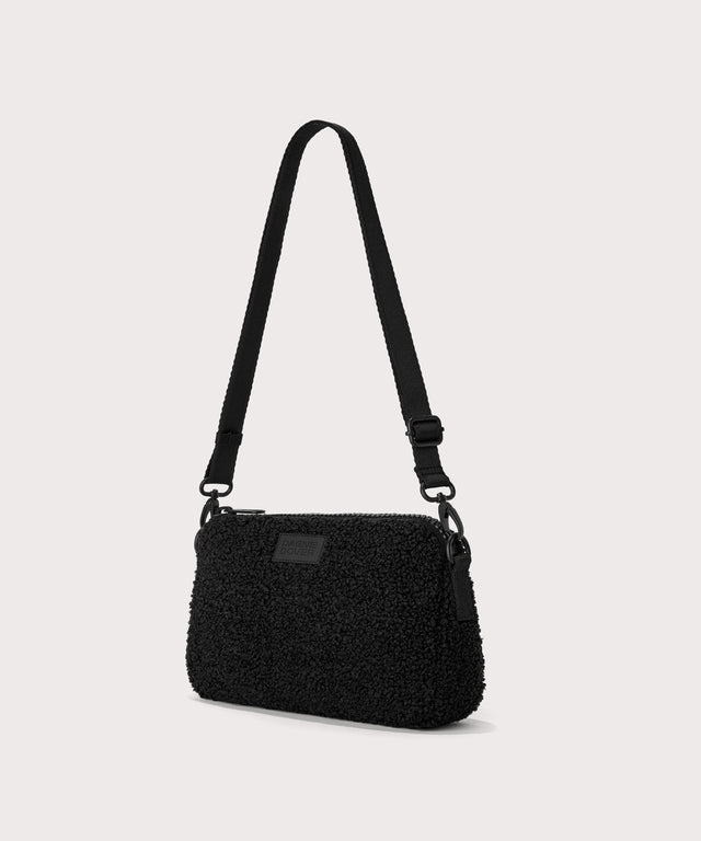 nora shoulder bag in a black..  side angle view  In a  Faux Shearling  a soft, wool-like plush made with recycled materials
