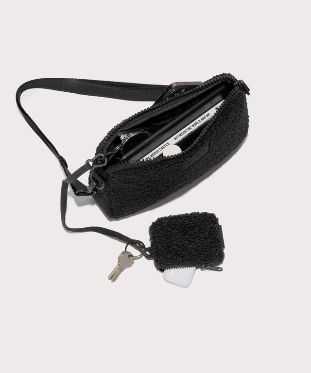 nora shoulder bag in a black . unzipped, top down view.  In a  Faux Shearling  a soft, wool-like plush made with recycled materials
