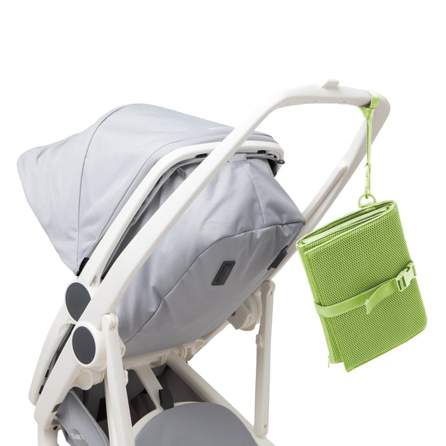 Dagne Dover Joey Changing Kit in matcha green strapped to the handle of a stroller.