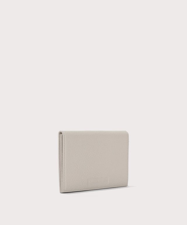 Dagne Dover Accordion Travel Wallet in light grey seen from an angle.
