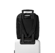 Dagne Dover Kal Drawstring Tote in black strapped to luggage with the luggage-handle sleeve.