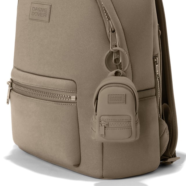 Dagne Dover Dakota Keychain in a medium-dark, creamy tan clipped onto a backpack. hover