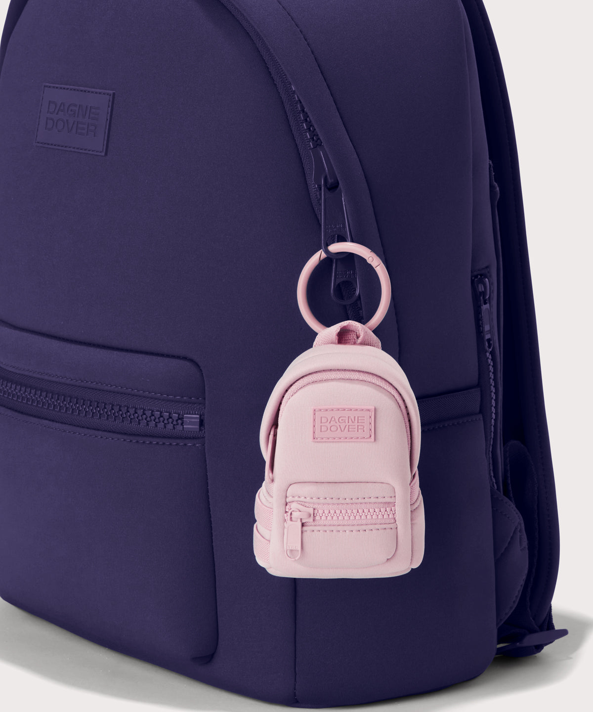 Dakota keychain in a cool, powdery pink with soft grey undertones. front angle shown on a dakota backpack. 
