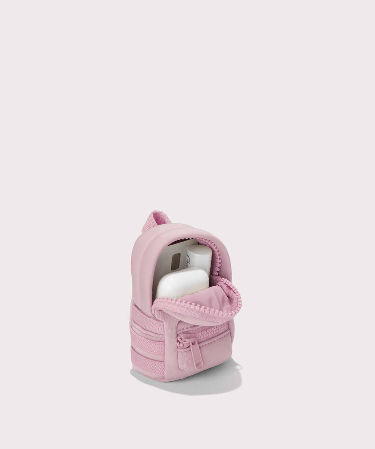 Dakota keychain in a cool, powdery pink with soft grey undertones.s. unzipped, top down view. 
