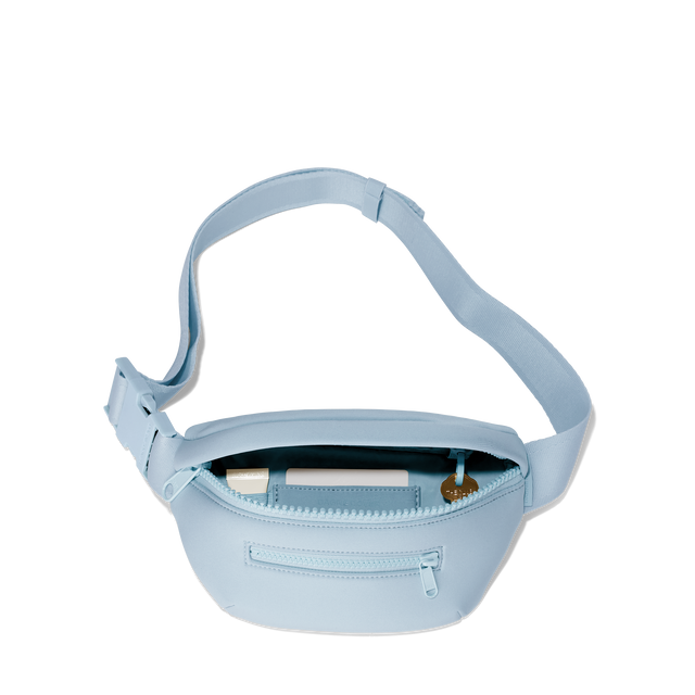 Dagne Dover Ace Fanny Pack in an airy, lighter sky blue unzipped, exposing the interior pockets. hover
