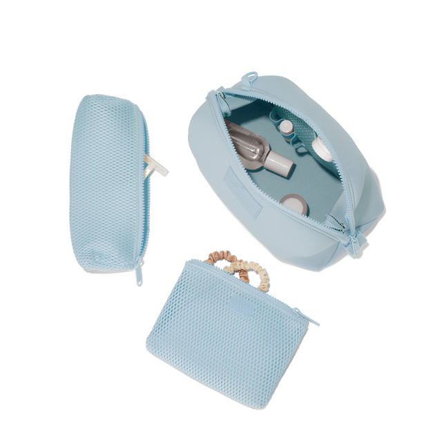 Dagne Dover Large Hunter Toiletry Bag in an airy, lighter sky blue unzipped and seen from above with the removable air mesh pouch alongside it. hover
