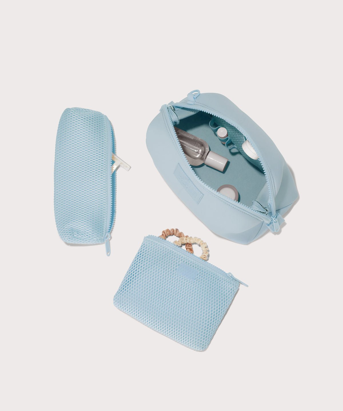 Dagne Dover Large Hunter Toiletry Bag in an airy, lighter sky blue. unzipped and seen from above with the removable air mesh pouch alongside it.