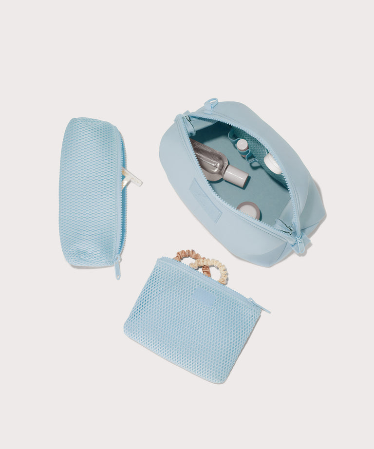 Dagne Dover Large Hunter Toiletry Bag in an airy, lighter sky blue. unzipped and seen from above with the removable air mesh pouch alongside it.