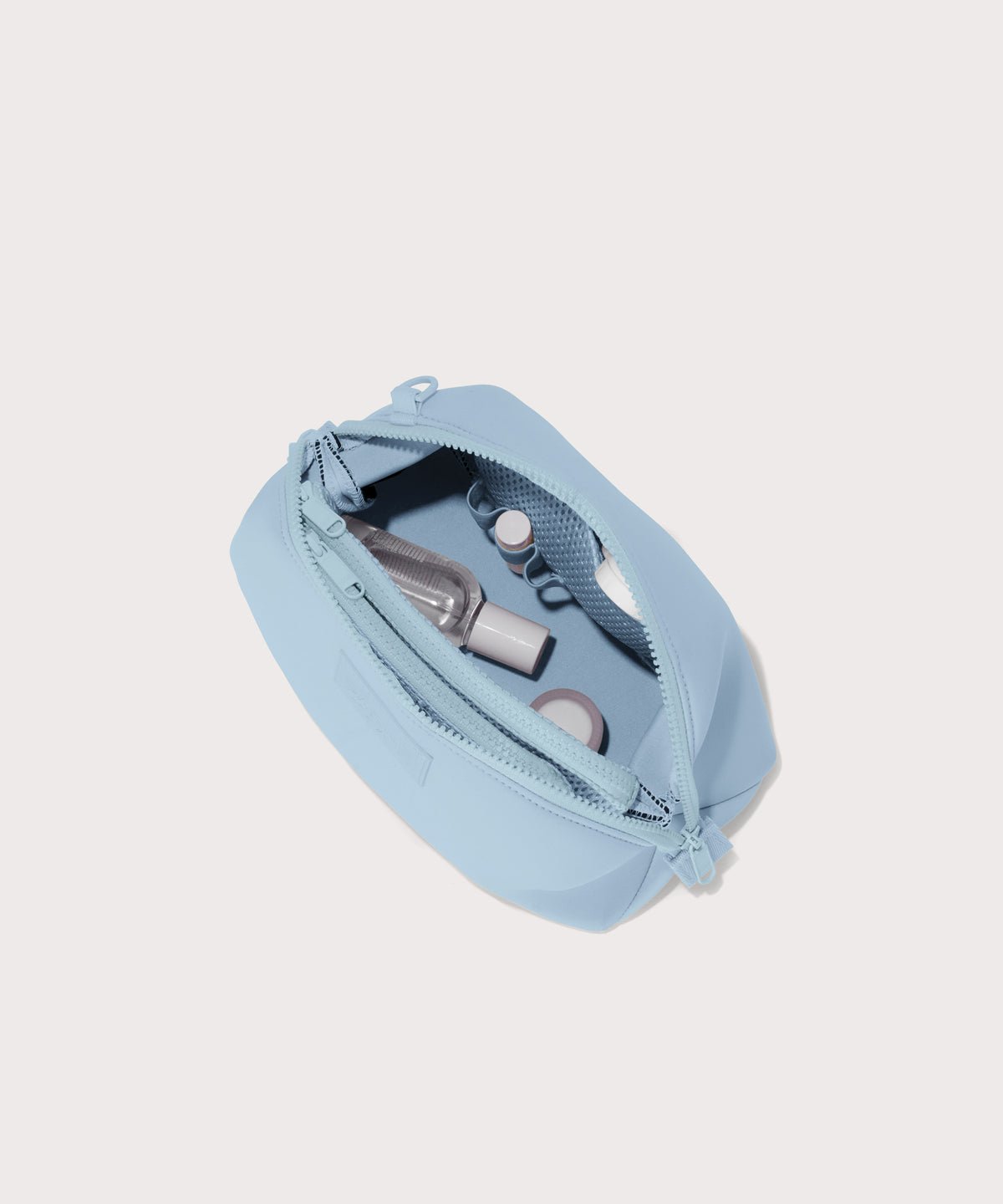 Dagne Dover large Hunter Toiletry Bag in an airy, lighter sky blue unzipped and seen from above.
