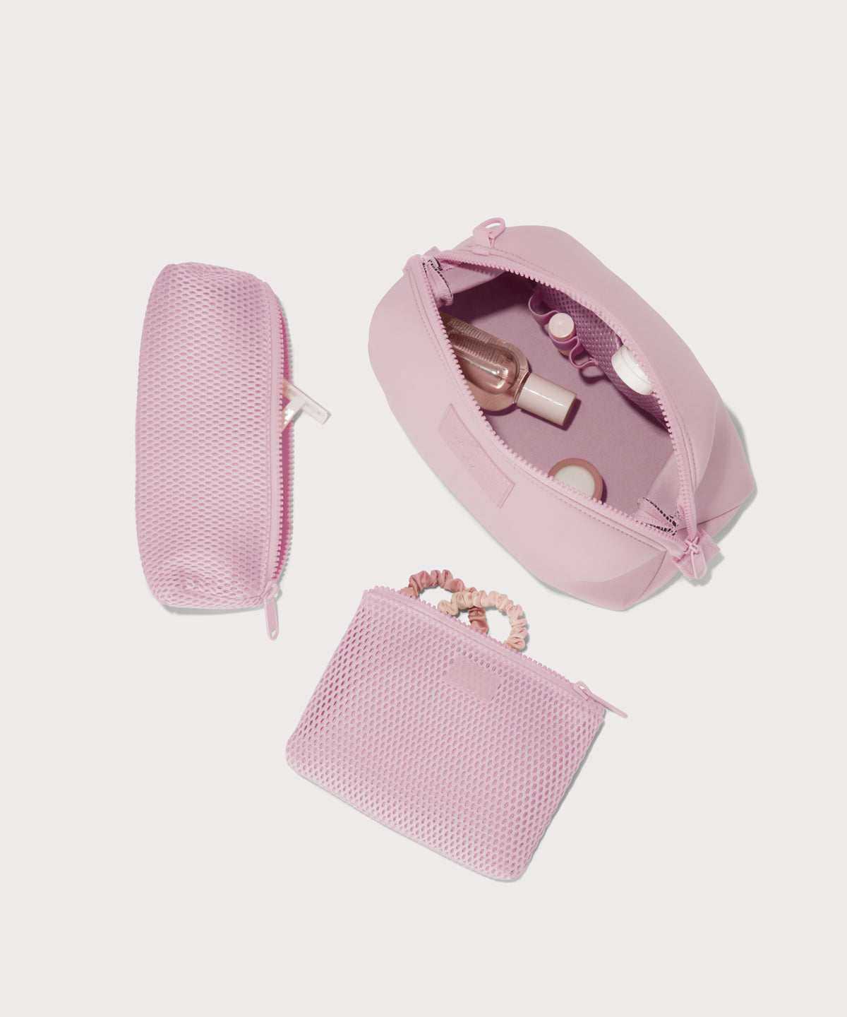 Hunter Large toiletry bag in a cool, powdery pink with soft grey undertones unzipped, top down view. 
