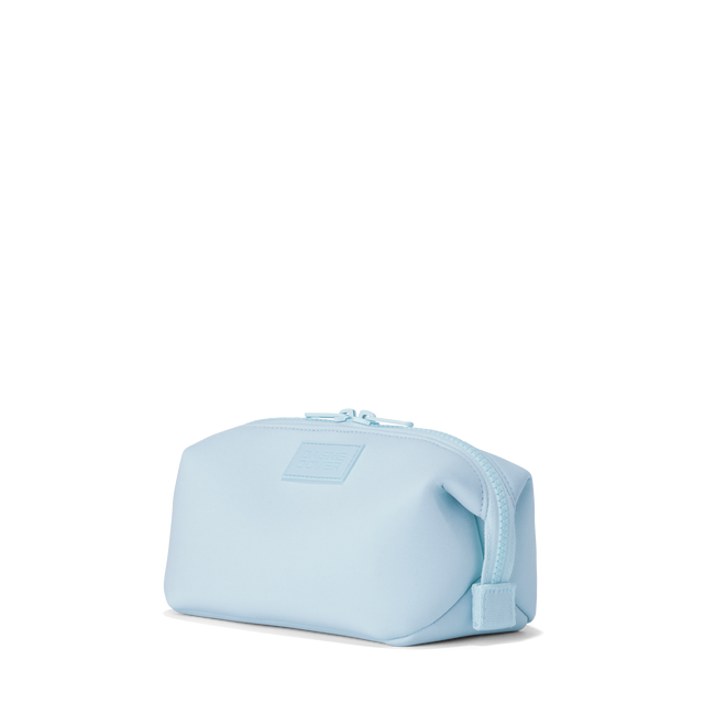 Dagne Dover small Hunter Toiletry Bag in an airy, lighter sky blue seen from an angle.
