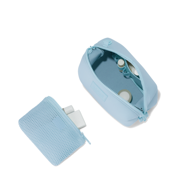 Dagne Dover small Hunter Toiletry Bag in an airy, lighter sky blue unzipped and seen from above with the removable air mesh pouch alongside it. hover
