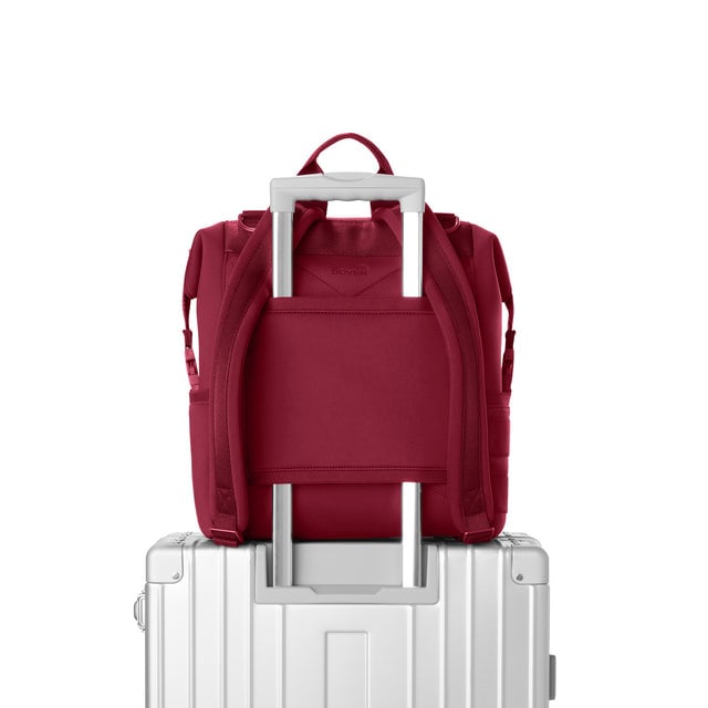 Dagne Dover Medium Indi Diaper Backpack in a punchy, saturated deep red showing the neoprene luggage sleeve.