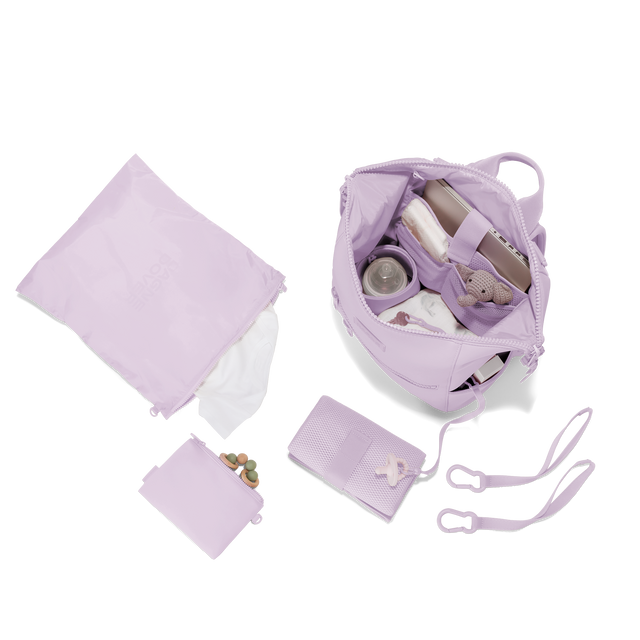 Dagne Dover medium Indi Diaper Backpack in a soft purple with grey undertones showing it's water resistant bag, interior pockets, and changing mat. Hover
