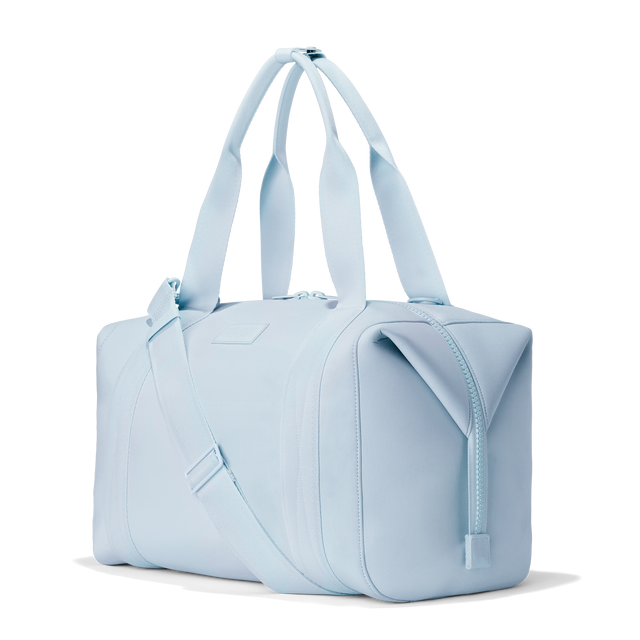 Dagne Dover large Landon Carryall in an airy, lighter sky blue, seen from an angle.
