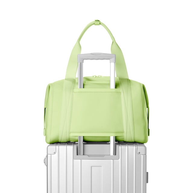Dagne Dover Large Landon Carryall in a vibrant, creamy green, displaying luggage sleeve.