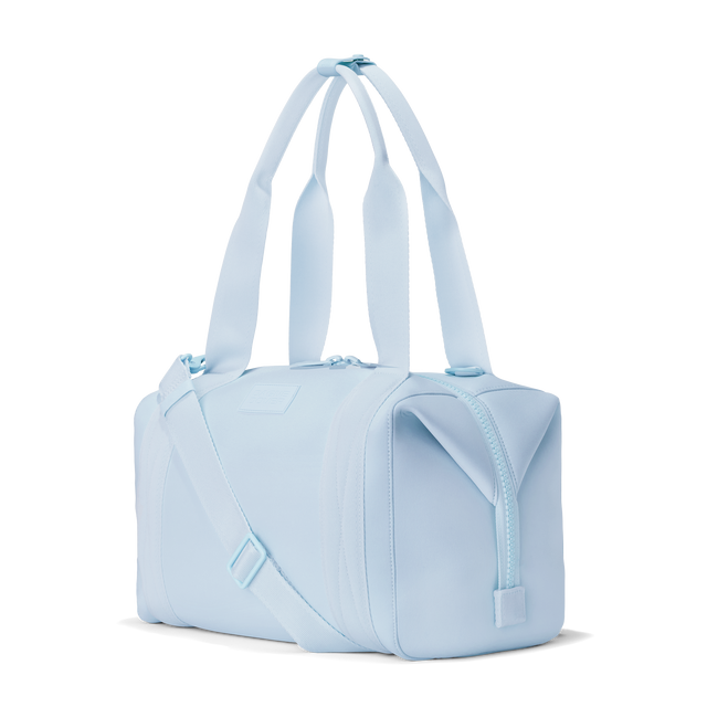 Dagne Dover medium Landon Carryall in an airy, lighter sky blue, seen from an angle.
