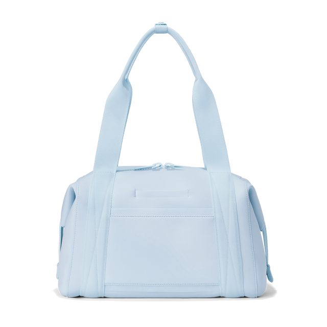 Dagne Dover medium Landon Carryall in an airy, lighter sky blue seen from the back displaying an exterior phone pocket.
