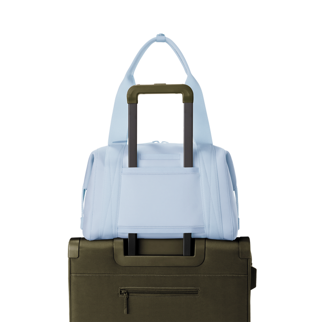 Dagne Dover medium Landon Carryall in an airy, lighter sky blue displaying luggage sleeve.
