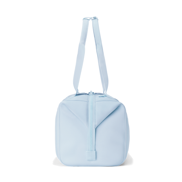 Dagne Dover medium Landon Carryall in an airy, lighter sky blue, seen from the side.
