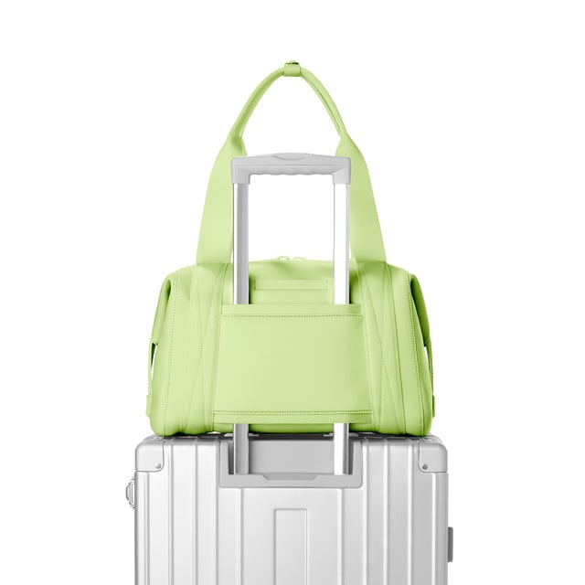 Dagne Dover Medium Landon Carryall in a vibrant, creamy green, displaying luggage sleeve.