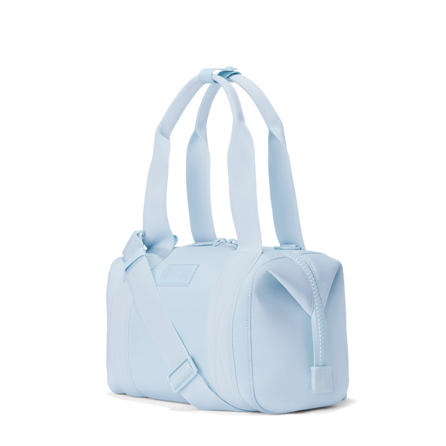 Dagne Dover small Landon Carryall in an airy, lighter sky blue, seen from an angle.
