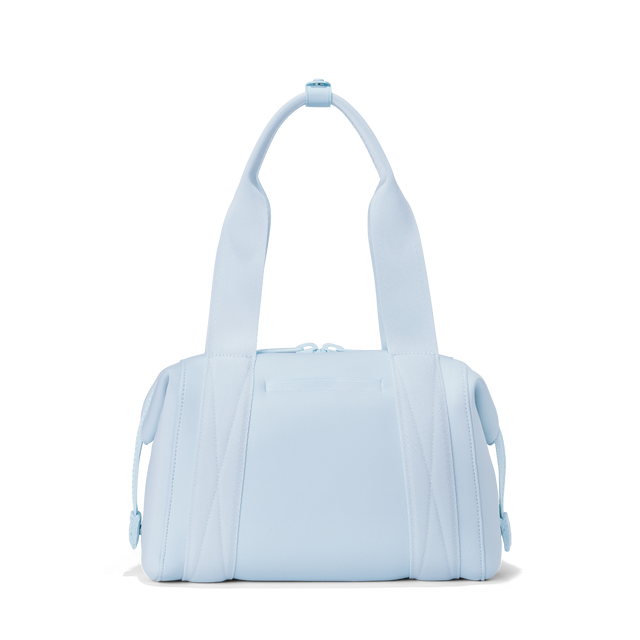 Dagne Dover small Landon Carryall in an airy, lighter sky blue seen from the back displaying an exterior phone pocket.
