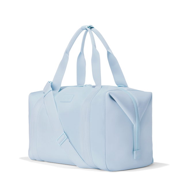 Dagne Dover extra large Landon Carryall in an airy, lighter sky blue, seen from an angle.
