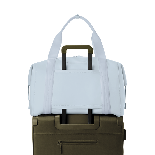 Dagne Dover extra large Landon Carryall in an airy, lighter sky blue displaying luggage sleeve.
